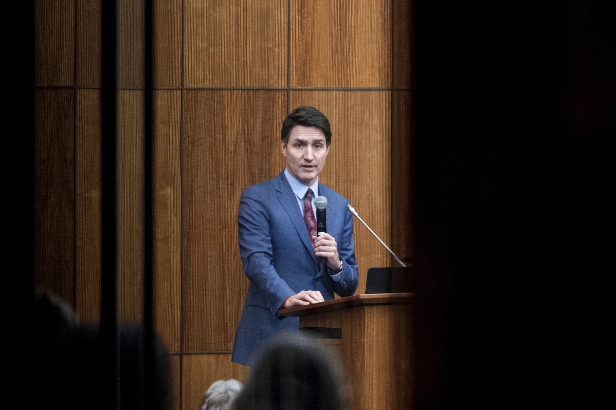 Canada’s Prime Minister Justin Trudeau is pictured through glass as he speaks with members of his caucus in Ottawa, Ontario, on Monday, Dec. 16, 2024. 