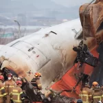 An excavator is used to lift burnt chairs from the wreckage of an aircraft that crashed after it went off the runway at Muan International Airport, in Muan, South Korea, December 29, 2024.