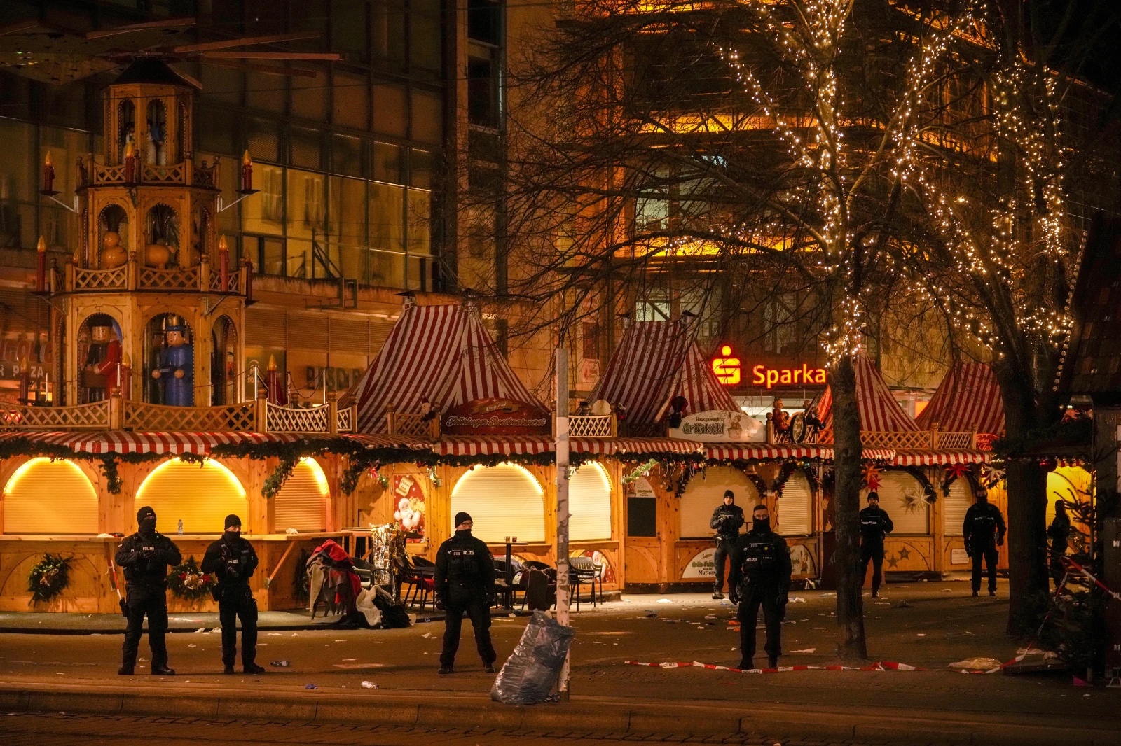 Security guards stand in front of a cordoned-off Christmas Market after a car crashed into a crowd of people, in Magdeburg, Germany, Saturday early morning, Dec. 21, 2024. 