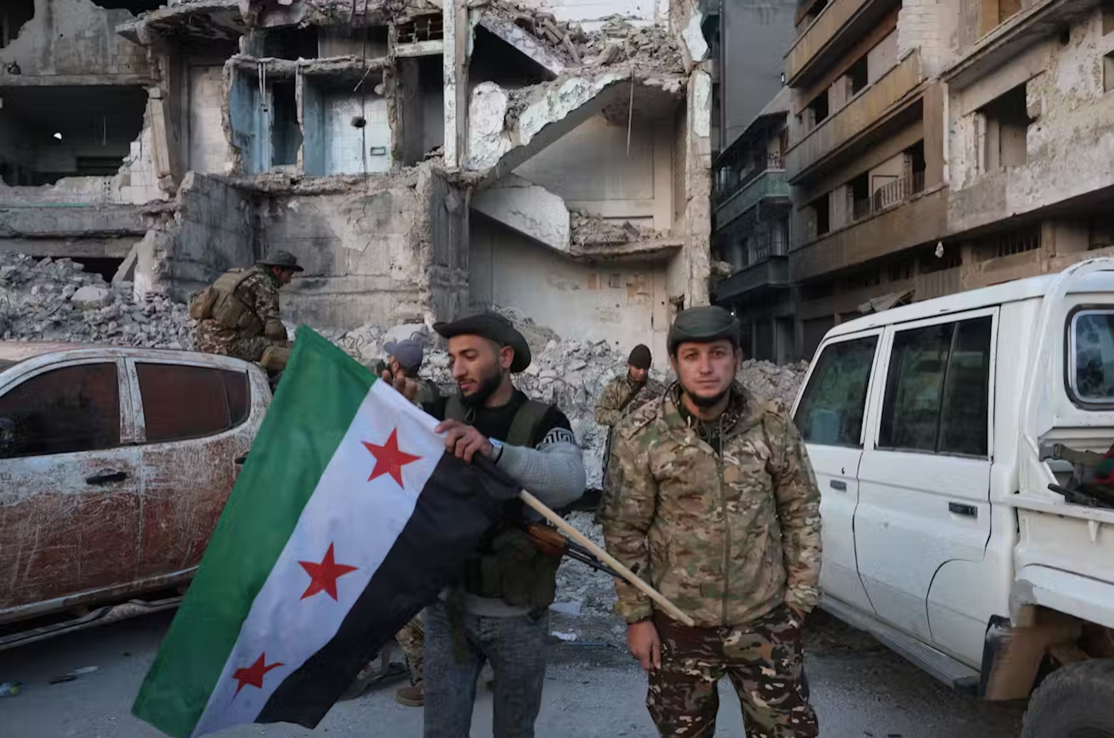 Syrian rebels pose with a Syrian opposition flag in Homs, Syria. 