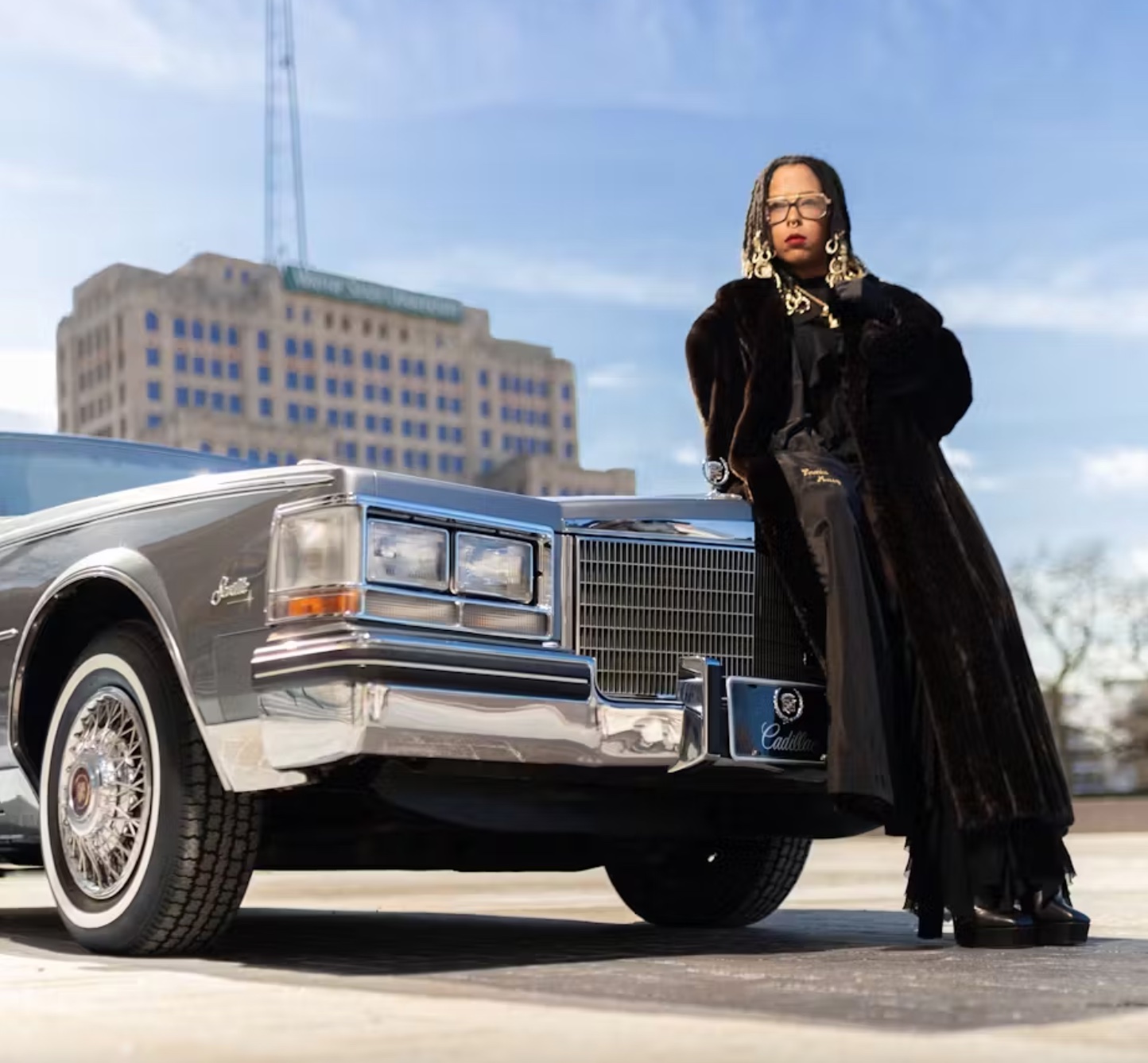 Tiff Massey poses with a Cadillac to promote her exhibition about metalsmithing, jewelry and the city’s streets. 