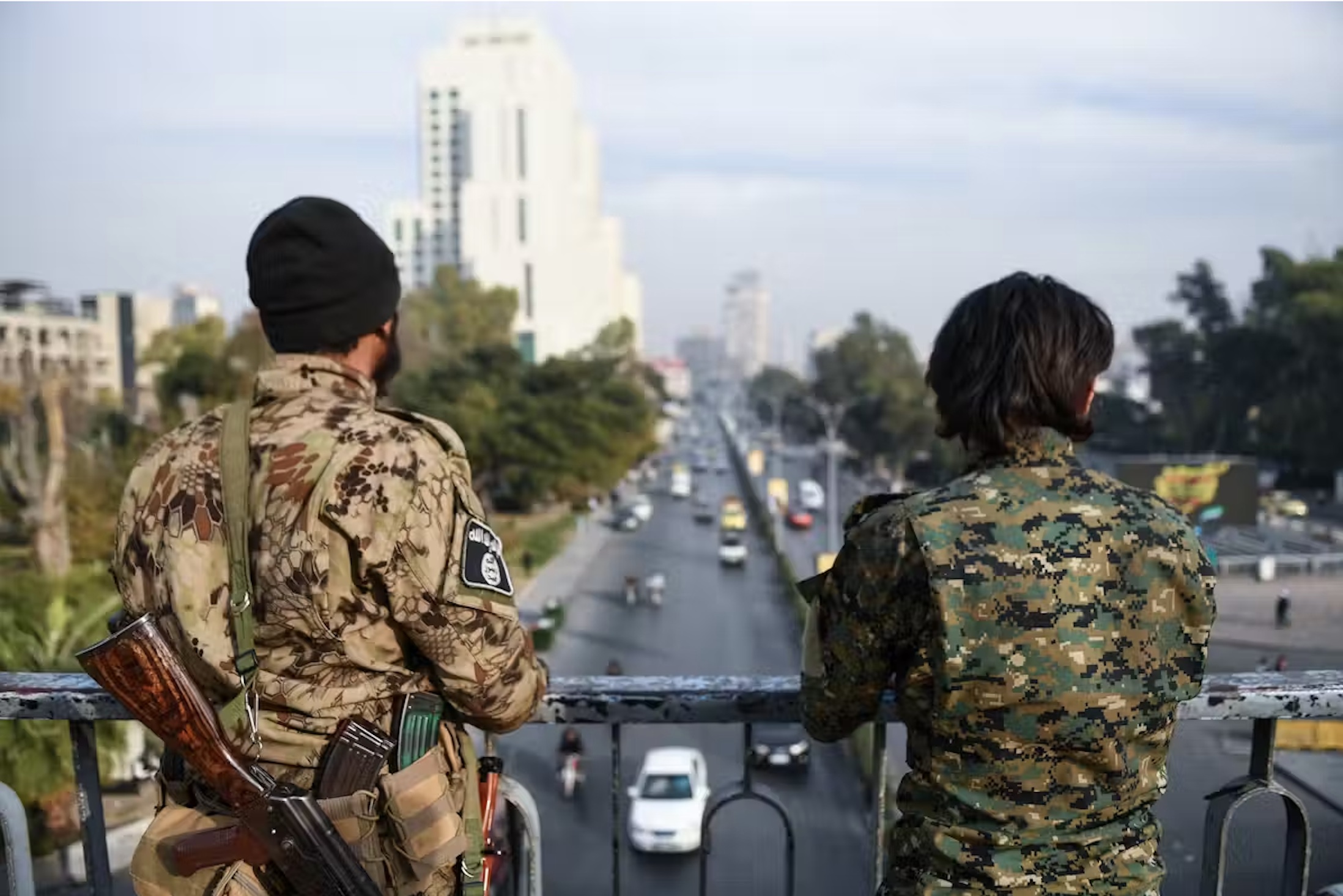 Two armed men keep watch over a road in Damascus, Syria, on December 11. 