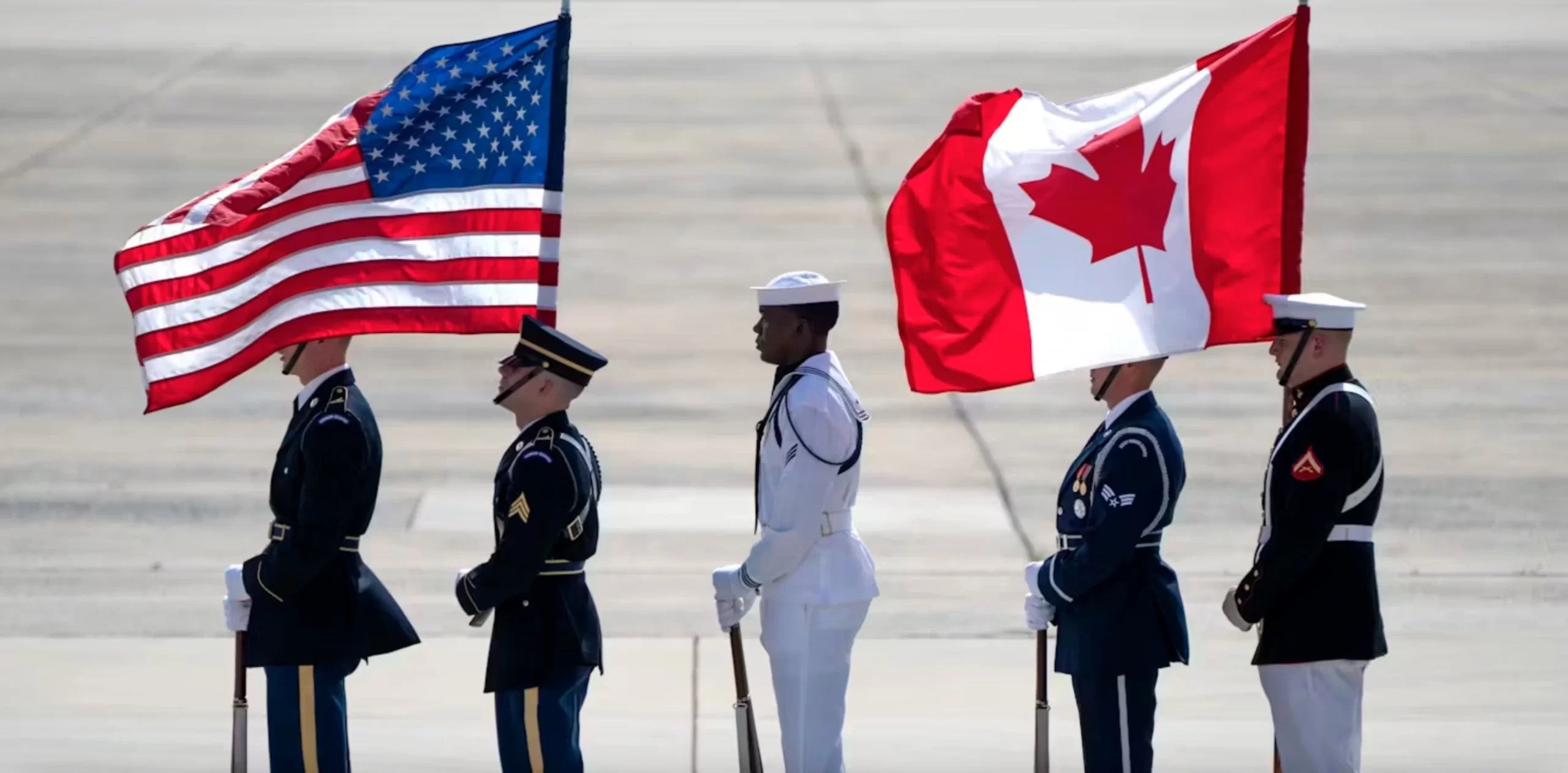 An honour guard stands with U.S. and Canadian flags in July 2024 as they wait for Canadian Prime Minister Justin Trudeau to arrive at Andrews Air Force Base, Md., to attend the NATO summit in Washington. 