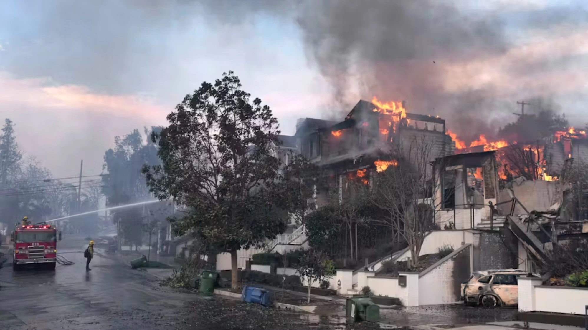 Firefighters work to extinguish burning homes in the Pacific Palisades neighborhood of Los Angeles on Jan. 8, 2025. 