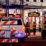 Law enforcement vehicles and people stand near the area near the scene where a vehicle drove into a crowd during New Year's celebrations, in New Orleans, Louisiana, U.S., January 1, 2025.