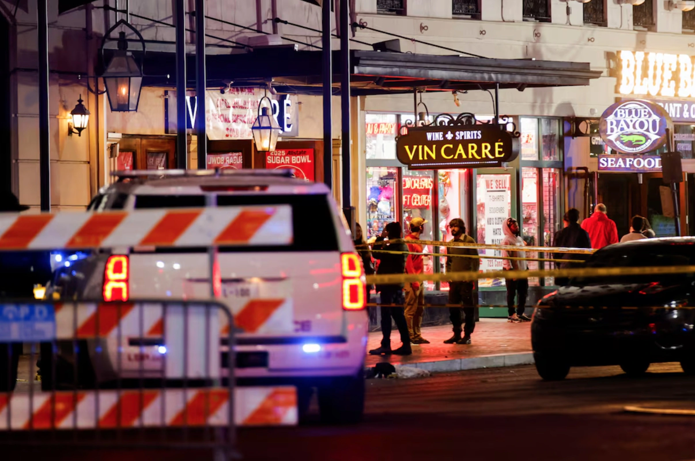 Law enforcement vehicles and people stand near the area near the scene where a vehicle drove into a crowd during New Year's celebrations, in New Orleans, Louisiana, U.S., January 1, 2025. 