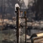 Water runs from a pipe where a home once stood in the Pacific Palisades community of Los Angeles in January 2025.