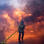 A firefighter battles the Palisades Fire as it burns during a windstorm on the west side of Los Angeles, California, U.S. January 7, 2025.